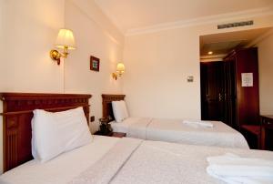 a hotel room with two beds with white sheets at Emine Sultan Hotel in Istanbul