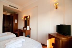 a hotel room with two beds and a flat screen tv at Emine Sultan Hotel in Istanbul