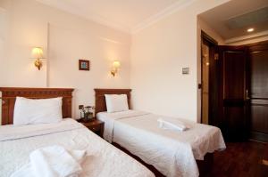 a hotel room with two beds with white sheets at Emine Sultan Hotel in Istanbul