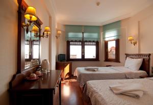a hotel room with two beds and a mirror at Emine Sultan Hotel in Istanbul