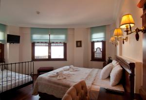 a bedroom with a bed and two windows at Emine Sultan Hotel in Istanbul