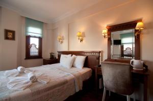 a hotel room with a bed and a desk and a mirror at Emine Sultan Hotel in Istanbul
