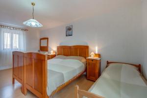 a bedroom with a bed and a sink and a mirror at Armida in Veli Lošinj