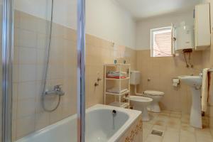 uma casa de banho com uma banheira, um WC e um lavatório. em Armida em Veli Lošinj