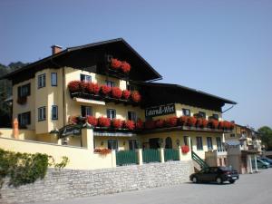 a building with flowers on the side of it at Laterndl-Wirt in Sankt Veit im Pongau