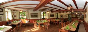 un restaurante con mesas de madera y sillas con servilletas verdes en Gasthof Graf, en Steingaden