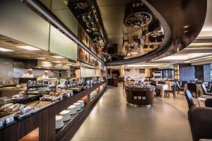 a restaurant with a buffet line with people preparing food at Hotel Del Lago in Yuchi