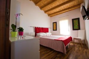 een slaapkamer met een bed met een rode deken bij Experience Il Paesino in Licodia Eubea