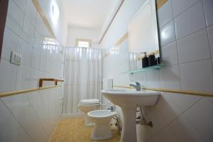 a white bathroom with a sink and a toilet at Experience Il Paesino in Licodia Eubea +91 photos