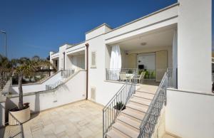 a white house with stairs and a patio at Villetta Pistacchio & Ribes in Marina di Pescoluse