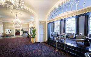 a large room with a chandelier and a piano at Riu Plaza The Gresham Dublin in Dublin