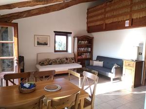 een woonkamer met een tafel en een bank bij Le Petit Rias Gîte Soleil in Saint Maurice en Chalencon