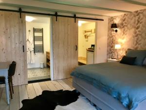 Schlafzimmer mit einem Bett, einem Schreibtisch und einer Tür in der Unterkunft Nabij de Molen in Wijdenes