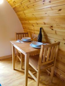 une table en bois avec deux chaises et un mur en bois dans l'établissement Colemans Cottage Fishery, à Wickham Bishops 6 autres photos