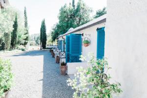 a white building with blue shutters on it at Kuilfontein Stable Cottages in Colesberg