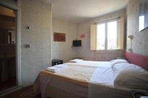 um quarto com uma cama grande e uma janela em albergo Fiorentino em Sansepolcro