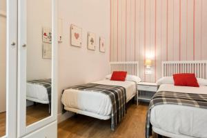 a small room with two beds and a mirror at Alohamundi Salvador in Seville