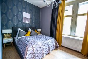 1 dormitorio con 1 cama con pared azul en Ruterra Apartments by Cathedral en Praga