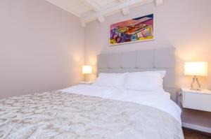 杜布羅夫尼克的住宿－弗洛雷斯別墅酒店，一间卧室配有一张带两盏灯的大型白色床。