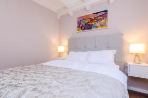 - une chambre avec un grand lit blanc et deux lampes dans l'établissement Villa Flores, à Dubrovnik