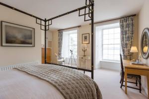 een slaapkamer met een bed, een bureau en ramen bij Barrow House in Tralee