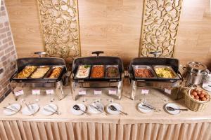 a buffet table filled with plates of food at Sunflower Avenue Hotel Moscow in Moscow