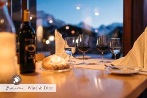 Hotel Bären - the Alpine Herb Hotel في ون قن: طاولة مع كؤوس للنبيذ وزجاجة من النبيذ