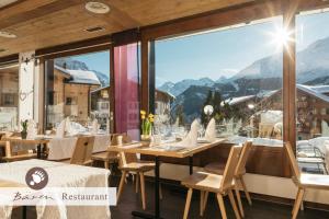 a restaurant with a view of the mountains at Hotel Bären - the Alpine Herb Hotel in Wengen