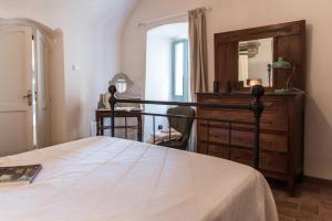 Un dormitorio con una cama, una cómoda y un espejo. en Foresteria Terra Majura, en Terni