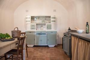 une cuisine avec des armoires bleues et un comptoir avec une table dans l'établissement Foresteria Terra Majura, à Terni