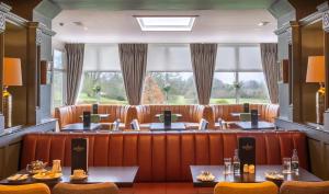 um restaurante com bancos de couro castanho e uma grande janela em Bloomfield House Hotel, Leisure Club & Spa em Mullingar