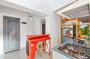 um banco vermelho numa cozinha com um fogão em Rezident Predeal em Predeal