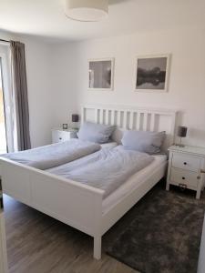 ein großes weißes Bett in einem Zimmer mit Fenster in der Unterkunft Ferienwohnung Selina-Sophie in Sehringen