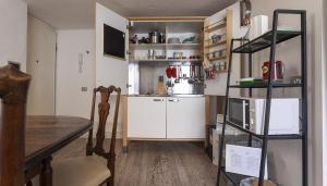 a small kitchen with white cabinets and a shelf at Italianway - Ripa di Porta Ticinese 17 in Milan