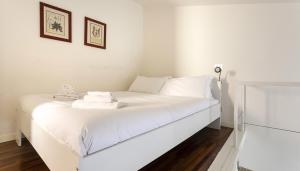 un letto bianco con asciugamani in una stanza di Italianway - Ripa di Porta Ticinese 17 a Milano