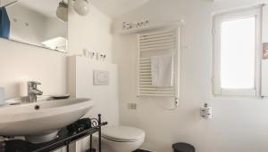a white bathroom with a sink and a toilet at Italianway - Ripa di Porta Ticinese 17 in Milan +22 photos
