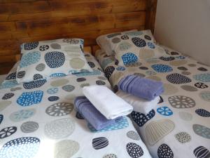 - deux lits avec des oreillers et des serviettes dans l'établissement Country House Speedy, à Komiža