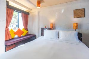 a bedroom with a large white bed and two windows at Punnpreeda Beach Resort - SHA Plus Certified in Bangrak Beach