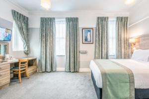 a hotel room with a bed and a desk at Lindum Lodge in Torquay