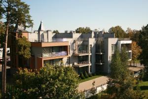 an image of a building with trees in the foreground at Sonia Apartments in Jūrmala