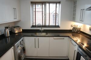 Una cocina con gabinetes blancos y un fregadero. en Letting Serviced Apartments - Chorleywood Village, en Chorleywood 14 fotos más