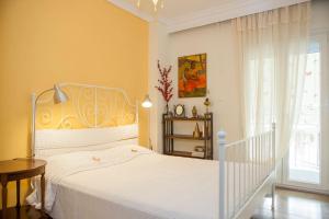 a bedroom with a white bed and a window at #FLH - Ethnic Flat, St Dimitrios in Thessaloniki
