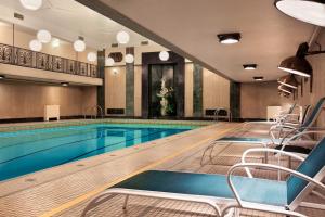 Fairmont Chateau Laurier Gold Experience في أوتاوا: مسبح مع كراسي في غرفة الفندق