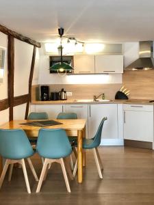 eine Küche mit einem Holztisch und blauen Stühlen in der Unterkunft Thomasmühle Ferienwohnungen in Leutershausen
