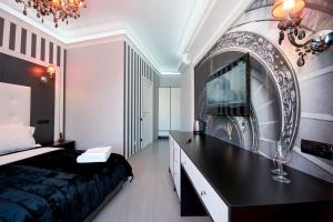 a bedroom with a bed and a tv on a wall at Partner Guest House Velyka Vasylkivska in Kyiv