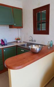 een keuken met een wastafel en een kom op een aanrecht bij Apartamentos Costa Menorca in Cala'n Bosch
