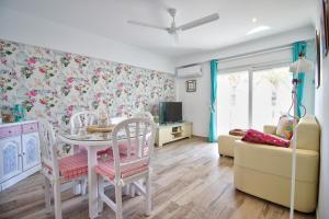 een woonkamer met een tafel en stoelen en een televisie bij Apartamentos Oliver Playa in Denia
