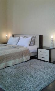 a bedroom with a bed with a night stand and a rug at Smile Khreschatyk Kyiv in Kyiv