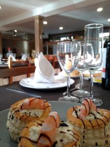 a table with two plates of pastries and wine glasses at Balneario Casa Pallotti in Carranza