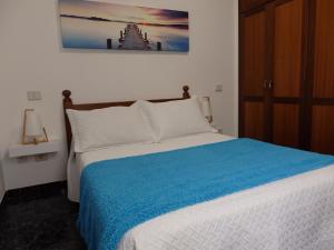ein Schlafzimmer mit einem Bett mit einer blauen Decke in der Unterkunft Toni's in Arinaga